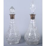 A pair of Mappin & Webb silver topped cut glass decanters and two stoppers