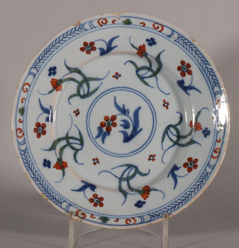 An 18th century Bristol delft plate with polychrome floral decoration, 8 3/8" dia (stabilised crack)