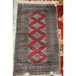 A Pakistan Bokhara rug with five star guls on a red ground, 64" x 38" approx