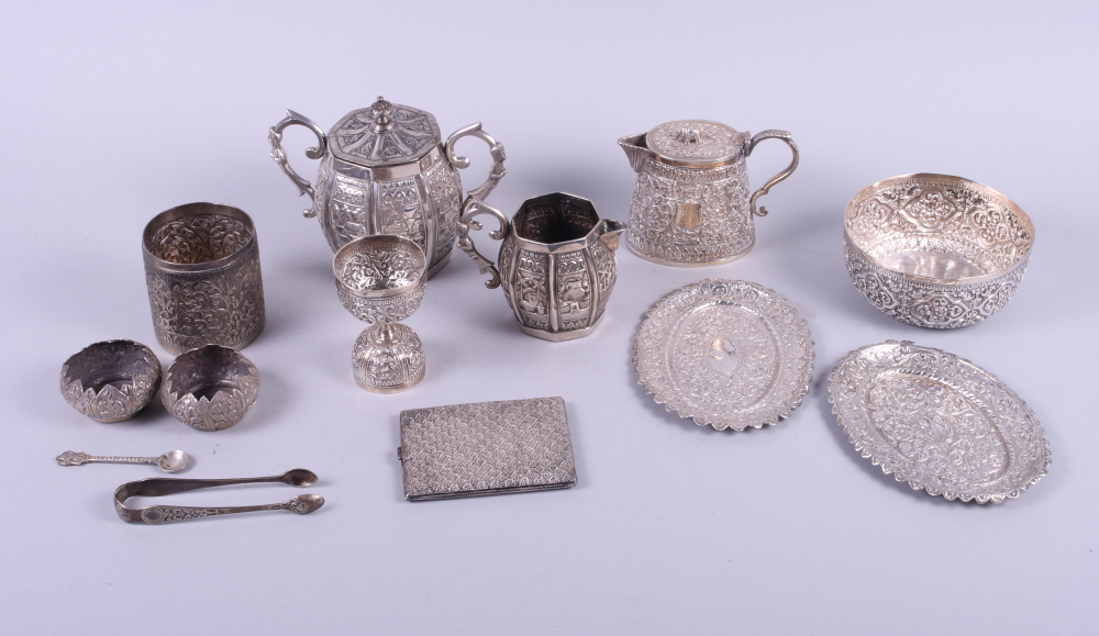 A group of Indian white metal objects, including a two-handle lidded sugar bowl, a milk jug, a