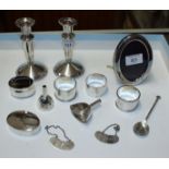 A pair of loaded silver candlesticks, 5" high, a silver frame, two spirit labels and various other