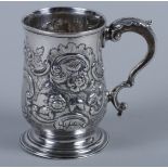 A George III silver christening mug, embossed with scroll and flower decoration and scroll handle