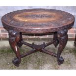 A carved teak oval top table, on cabriole supports, 36" wide