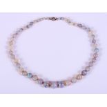 An early 20th century graduated opal bead necklace with a gold platinum topped and milgrain