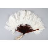 An early 20th century white ostrich feather fan with faux tortoiseshell sticks and guards, 10" long