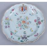 A late 19th century Chinese export porcelain armorial charger with scalloped edge, decorated with