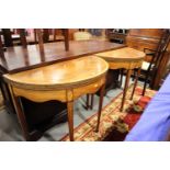 A pair of Edwardian inlaid mahogany demi-lune fold-over card tables, on square tapered supports