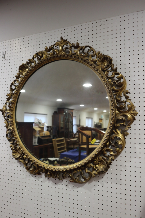 A carved giltwood framed circular wall mirror, plate 20" dia