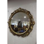 A carved giltwood framed circular wall mirror, plate 20" dia