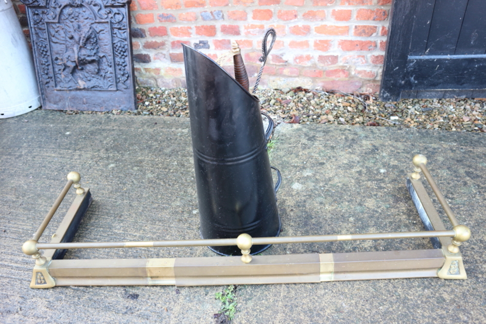 An Edwardian brass scroll end fender curb, a coal hod and a poker