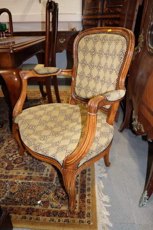 An Edwardian walnut open armchair, button upholstered in a brown leather, and a companion nursing