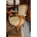 An Edwardian walnut open armchair, button upholstered in a brown leather, and a companion nursing