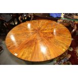 A mid 19th century figured mahogany circular tilt top dining table, on faceted column and lion paw