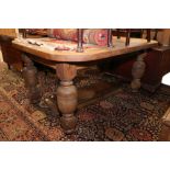 A late 19th century oak extending dining table, with two extra leaves, on cup and cover supports,