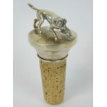 A white metal bottle stopper with huntin