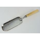 A silver plated crumb scoop.