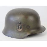 A WWII German helmet, later camo painted