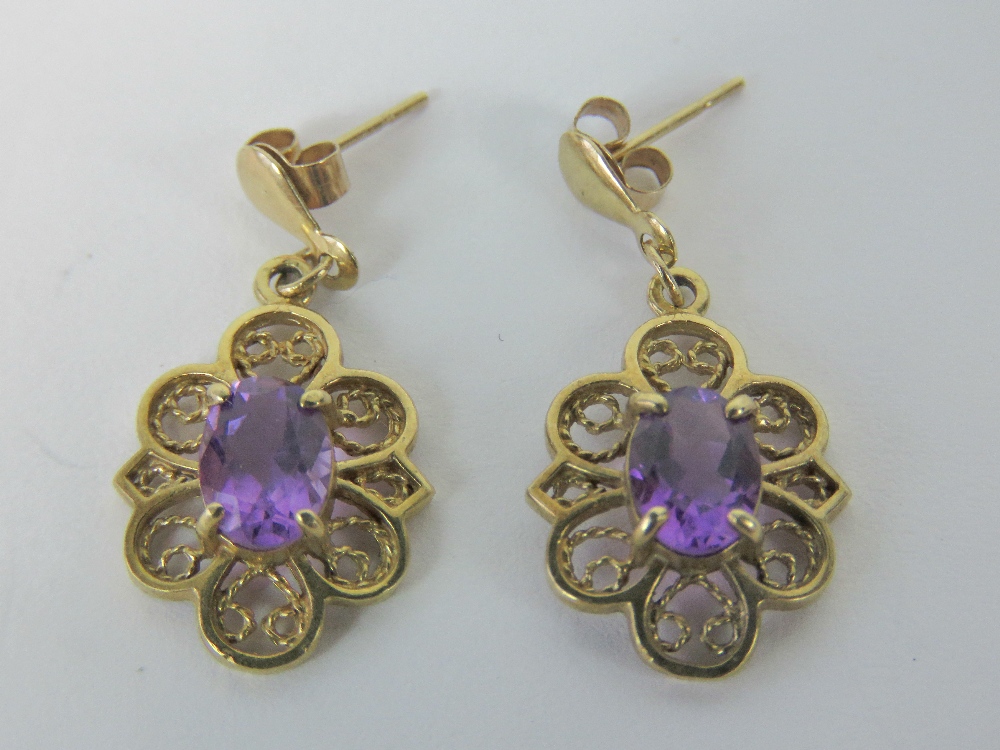 A pair of 9ct gold amethyst earrings, each with central oval amethyst of good purple hue, approx 0.