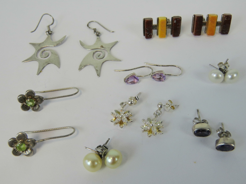 A quantity of assorted silver earrings including; pearl studs, geometric amber earrings,