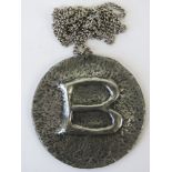 A Norwegian 1970s circular pendant initialled 'B' in beaten pewter foil, 6.