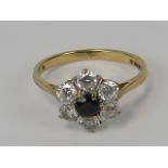 A 9ct gold sapphire and white stone daisy cluster ring, central round cut sapphire approx 0.