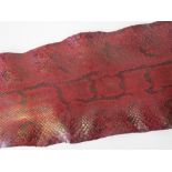 A tanned and red stained snakeskin measuring 215cm in length.