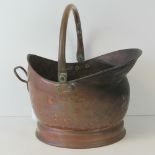 A vintage copper helmet coal scuttle, complete with swing handle and brass back handle,