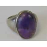 A silver and amethyst ring, large central amethyst cabachon approx 2 x 1.3cm, stamped 925, size Q.