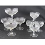 A set of four etched champagne saucers, together with matching set of four liqueur glasses.