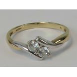 A 9ct white and yellow gold ring, two round cut white stones in twist design setting,