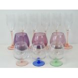 A set of six champagne flutes with pink stems,