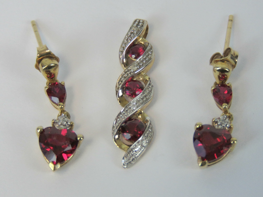 A suite of 9ct gold ruby and diamond jewellery comprising earrings and pendant.
