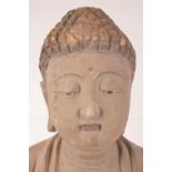 A Tibetan 19th century carved wooden Shakyameni Buddha statue showing traces of polychromatic paint