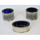 A pair of HM silver pierced salts with Bristol blue glass liners (one liner is a replacement),