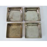 A set of four HM silver graduated hors d'oeuvres dishes of square form,