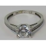 A 9ct white gold ring, central round cut white stone with further stones upon the shoulders,