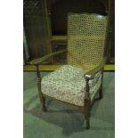 A c1930s bergere-back fireside open armchair with oversprung cushion