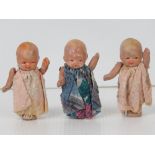 Three miniature porcelain baby dolls with articulated arms, in played with condition.