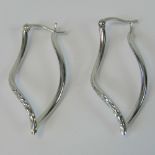 A pair of 9ct white gold earrings, faceted wave design hoop, hallmarked 375, 1.7g.