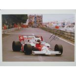 An Alain Prost signed coloured photograph with McLaren at Monaco, mounted, 24cm x 37cm.