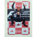 A signed coloured photograph of Mark Webber, 'The Jump' at F1 British GP, Silverstone 2010,