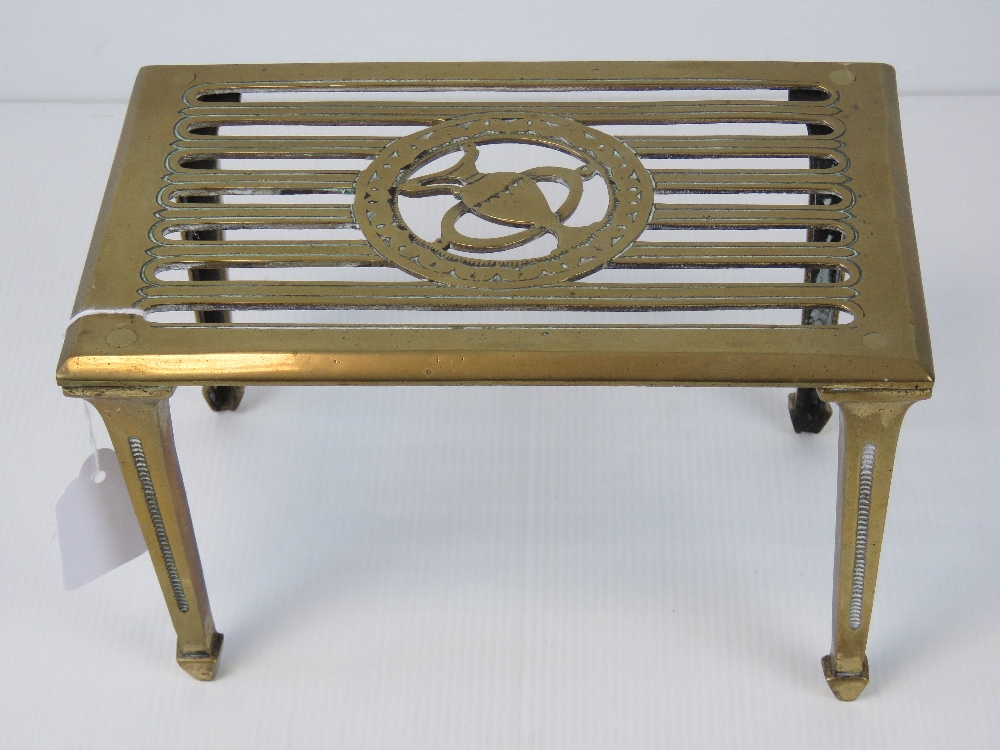 A heavy brass trivet, 23.5cm wide.