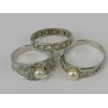 A suite of three silver rings; eternity