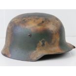 A WWII German camo helmet with later painted Italian Alp style camo,