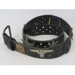 A black leather belt with applied military and other badges including;