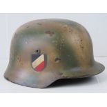 A WWII German Army helmet, double decal, later painted North Africa camo,