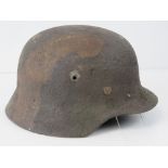 A WWII German M40 camo helmet with original liner and chin strap.