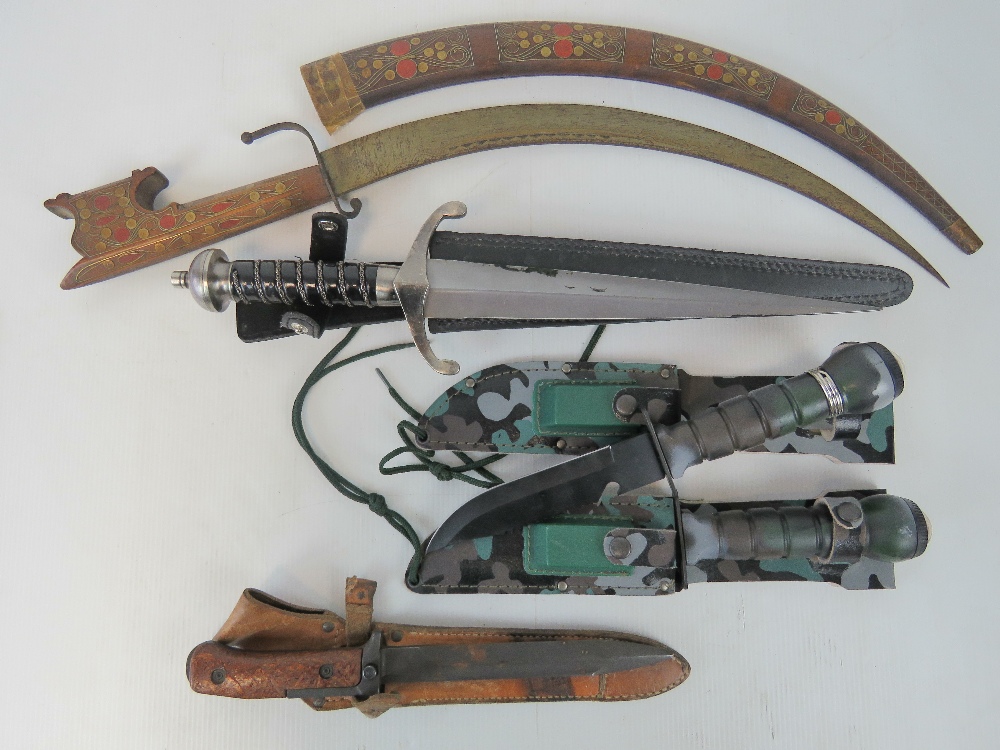 A Middle Eastern short sword, a dagger, a bayonet, and two Commando style knives with compasses.