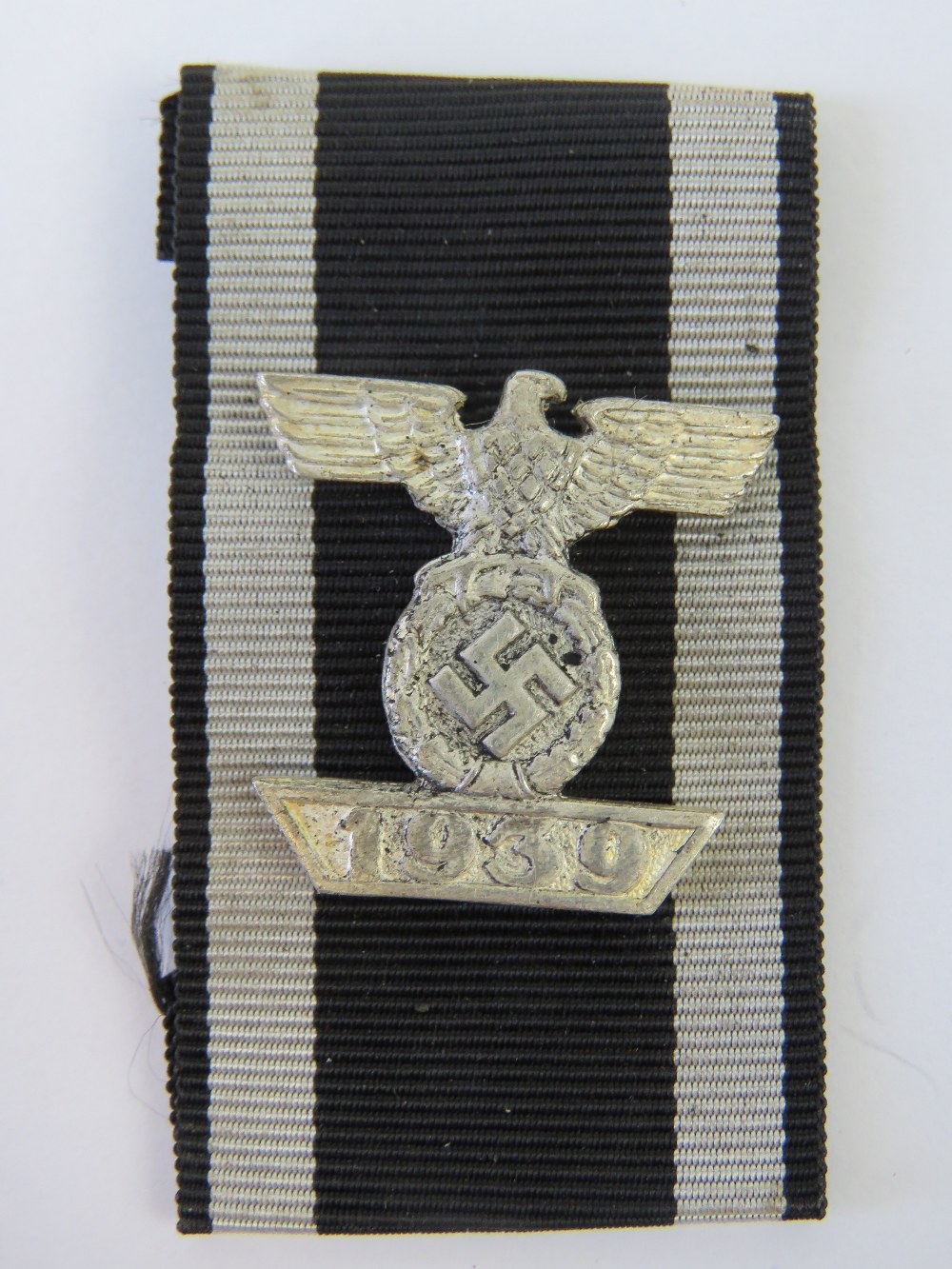 A WWII German Iron Cross bar with ribbon.