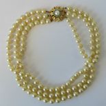 A faux pearl necklace with delightful yellow metal clasp set with cultured pearl and turquoise